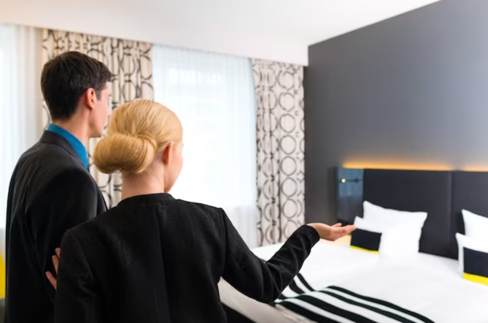 a man and a woman assessing a hotel room