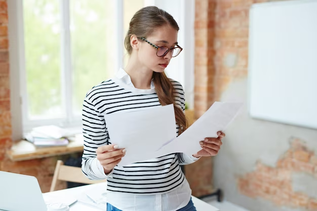 Woman with glasses reading documents