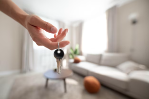 Hand holding keys against the background of the room